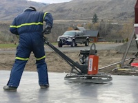 Power troweling concrete floor of new shop built by bavariancottages.com